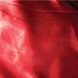 Close up of an apple red silk tablecloth.
