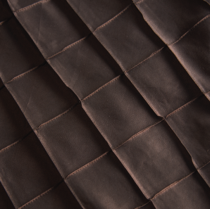 Close up of a chocolate brown pin tuck tablecloth.