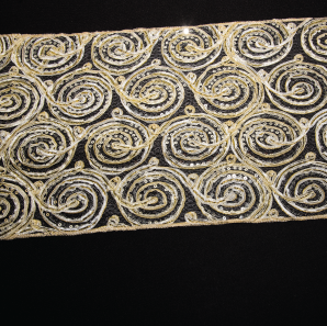 Close up of a gold swirled sequined table runner.