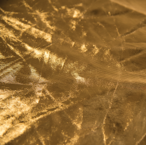 Close up of a metallic gold spandex tablecloth.