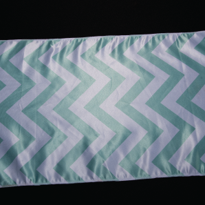 Close up of a mint colored chevron striped table runner.