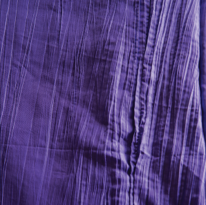 Close up of a purple crinkled accordion tablecloth.