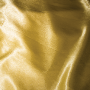 Close up of a yellow silk tablecloth.